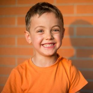 Child standing in front of building. Child standing in front of building.